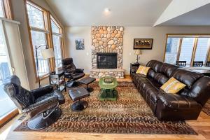 a living room with a leather couch and a fireplace at River Retreat - Permit #3517 in Estes Park
