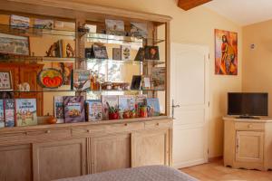 a room with a large wooden hutch with books at Le Clos des Oliviers in Le Rouret