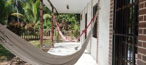 a hammock hanging on the side of a house at Flor de Sacuanjoche, Chinandega in Chinandega