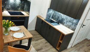 a small kitchen with a wooden table and a sink at Apartament - Sienkiewicza 22D in Zamość