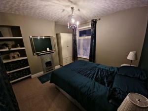 a bedroom with a bed and a television and a chandelier at 1 bedroom Sculcoates house Hull in Hull