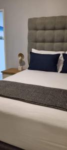 um quarto com uma cama grande e almofadas azuis em Oceanic Unit 122 - Durban North Beach em Durban