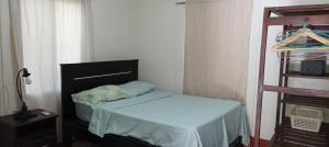 a small bedroom with a bed and a shelf at Flor de Sacuanjoche, Chinandega in Chinandega