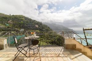a table and chairs on a balcony with a view of the ocean at #La limonaia della torretta in Minori