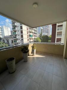 un balcón vacío con dos macetas en un edificio en Departamento 2 amb de lujo en Belgrano 2B en Buenos Aires