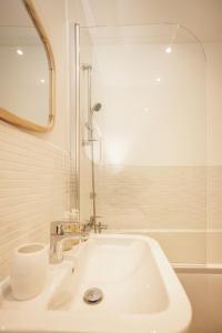 a white bathroom with a sink and a mirror at Upton Grange Townhouse sleeps 10 in Mollington