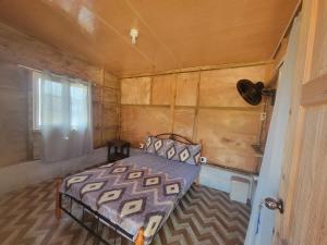 a bedroom with a bed in a wooden house at Johnny Fiestas in Las Lajas