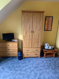 a bedroom with a wooden cabinet and a desk at Dal Riada B&B in Gweedore