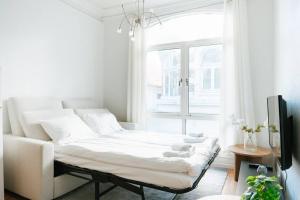 a white living room with a couch and a window at City Center Apartment in Bergen
