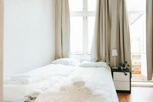 2 weiße Betten in einem Zimmer mit Fenster in der Unterkunft City Center Apartment in Bergen