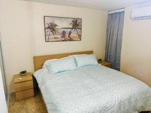 - une chambre avec un lit et une photo sur le mur dans l'établissement Ocean Breeze, à Punta Santiago