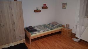 a small bedroom with a bed and a wooden floor at Apartman Barbara in Daruvar