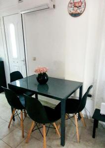 a table with chairs and a vase with flowers on it at Cosy apartment in Perea