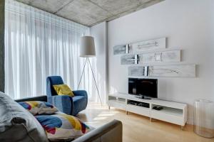 ein Wohnzimmer mit einem TV und einem blauen Stuhl in der Unterkunft Les Immeubles Charlevoix - 760-307 in Québec