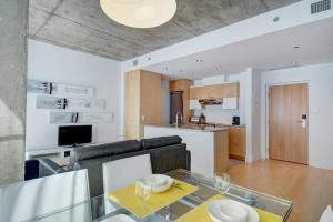 eine Küche und ein Wohnzimmer mit einem Glastisch in der Unterkunft Les Immeubles Charlevoix - 760-307 in Québec