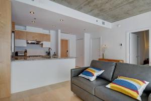 ein Wohnzimmer mit einem Sofa und einer Küche in der Unterkunft Les Immeubles Charlevoix - 760-307 in Québec