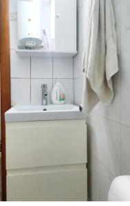 a bathroom with a white sink and a towel at Cosy apartment in Perea