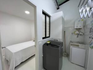 Habitación blanca pequeña con cama y ventana en Renewed 3hab/2bat in laureles, en Medellín