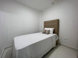 Dormitorio blanco con cama con almohada en Renewed 3hab/2bat in laureles, en Medellín