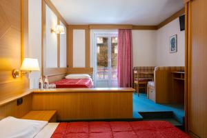 a hotel room with two beds and a window at Hotel La Serenella in Moena