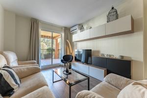 een woonkamer met 2 banken en een tv bij Seaside Bliss 2BR Apartment with Tranquil Terrace Pool and Parking in Fuengirola