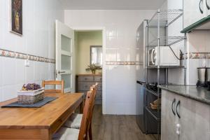 een keuken met een houten tafel en een eetkamer bij Seaside Bliss 2BR Apartment with Tranquil Terrace Pool and Parking in Fuengirola