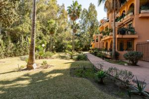 een binnenplaats met palmbomen en een gebouw bij Seaside Bliss 2BR Apartment with Tranquil Terrace Pool and Parking in Fuengirola