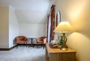 a room with a table with a lamp and chairs at The Bridge Helmsdale in Helmsdale