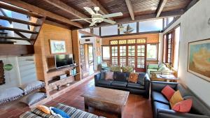 uma sala de estar com mobiliário de couro e uma ventoinha de tecto em Excelente localização, próximo ao centro e praias! em Búzios