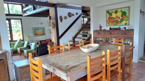 uma sala de jantar com uma mesa de madeira e cadeiras em Excelente localização, próximo ao centro e praias! em Búzios