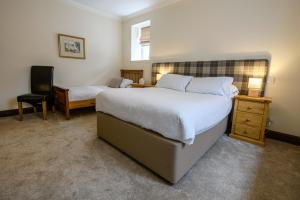 a bedroom with two beds and a desk and a chair at The Bridge Helmsdale in Helmsdale