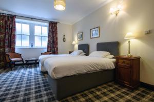 a hotel room with two beds and a window at The Bridge Helmsdale in Helmsdale