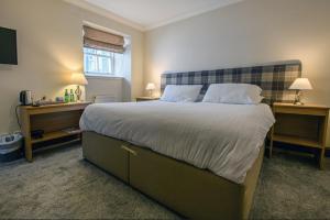a bedroom with a large bed with two night stands at The Bridge Helmsdale in Helmsdale