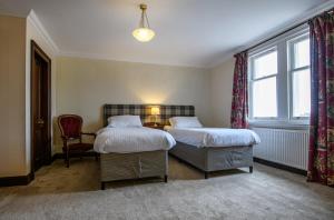 a hotel room with two beds and a window at The Bridge Helmsdale in Helmsdale