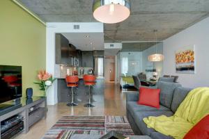 uma sala de estar com um sofá cinzento e uma cozinha em Les Immeubles Charlevoix - 760-510 em Cidade de Quebec