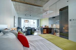 a bedroom with a large white bed with red pillows at Les Immeubles Charlevoix - 760-510 in Quebec City