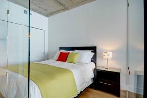 a bedroom with a large bed and a glass wall at Les Immeubles Charlevoix - 760-510 in Quebec City