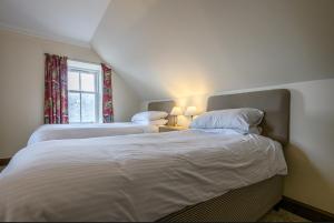 a bedroom with two beds and a window at The Bridge Helmsdale in Helmsdale