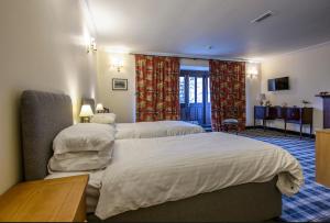 ein Hotelzimmer mit 2 Betten und einem Tisch in der Unterkunft The Bridge Helmsdale in Helmsdale