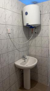 a bathroom with a sink and a water tank on the wall at Coco Island in Bathurst