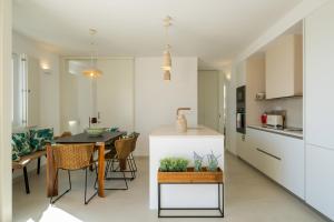 eine Küche und ein Esszimmer mit einem Tisch und Stühlen in der Unterkunft Casa dos Pedros (Beach House) in São Roque
