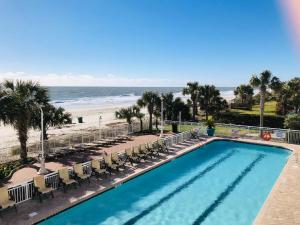 a pool with chairs and the beach in the background at Pristine Condo Glorious Ocean View HS 11th Floor in Myrtle Beach