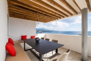 una sala da pranzo con tavolo e vista sull'oceano di Casa dos Pedros (Beach House) a São Roque