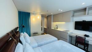 a bedroom with a bed and a desk and a tv at Grace Chapinero in Bogotá
