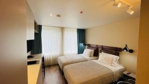 a hotel room with two beds and a television at Grace Chapinero in Bogotá +54 photos