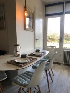 a dining room with a table and chairs and a window at Zee & Zand in Noordwijk