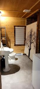 a bathroom with two sinks and a tree on the wall at Motel du Haut Phare in Cap-des-Rosiers