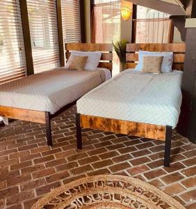 2 camas individuais num quarto com piso em tijolo em A Magical Treehouse by the Sea! em Hilton Head Island