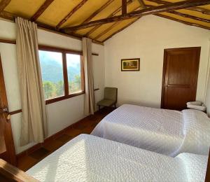 薩帕托卡的住宿－Campo Karst，卧室配有白色的床和窗户。