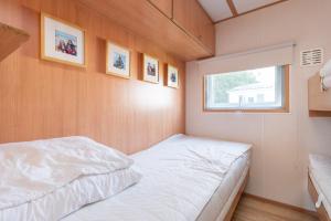 a small bedroom with a bed and a window at Heidehut in Midsland